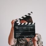 a woman holding a clapper over her face, movies, film, entertainment, opus, Moana