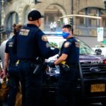 man in police uniform standing beside black car during daytime, arrest, police, arrested
