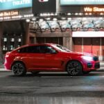 a red car parked in front of a theater, action, movie, film, set, Caught Stealing