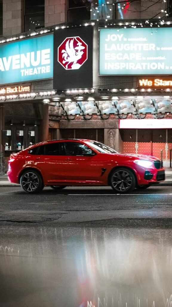 a red car parked in front of a theater, action, movie, film, set