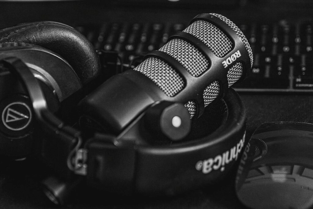 Close-up of a studio microphone and headphones in a black and white composition, perfect for audio and podcast themes. sounds, akon