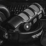 Close-up of a studio microphone and headphones in a black and white composition, perfect for audio and podcast themes. sounds, akon