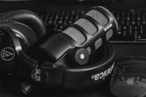 Close-up of a studio microphone and headphones in a black and white composition, perfect for audio and podcast themes. sounds, akon