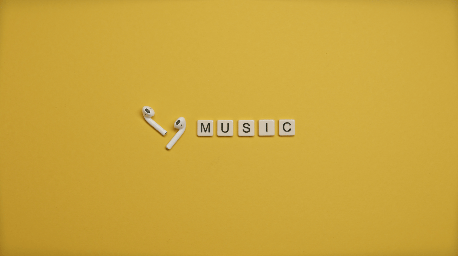 Minimalist image of AirPods and music-themed letter tiles on a vibrant yellow background. plays