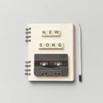 Close-up of a notebook with a vintage cassette and 'New Song' text, perfect for music lovers. Hilary Duff