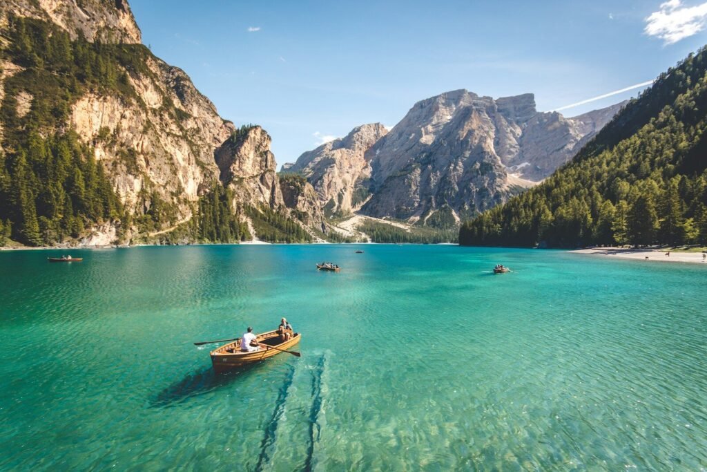 Travel 1 three brown wooden boat on blue lake water taken at daytime, travel