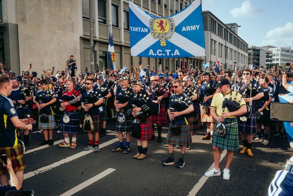 A group of men in kilts standing in front of a crowd, Tartan Army, Scotland